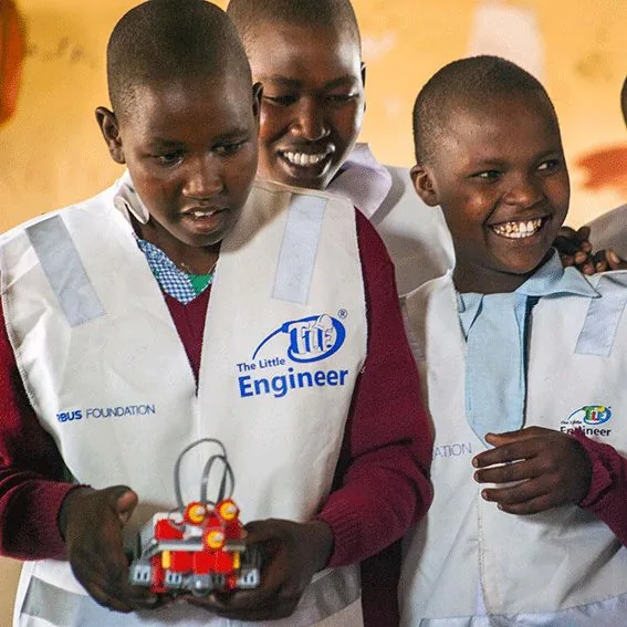 Students wearing Airbus Foundation and Little Engineer vests presenting a robot they built