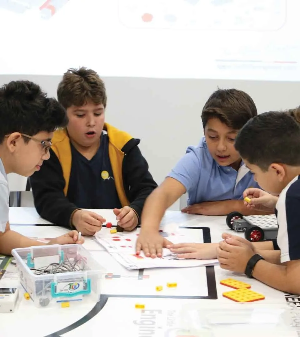 Students collaborating on a build around a table at a Little Engineer centre