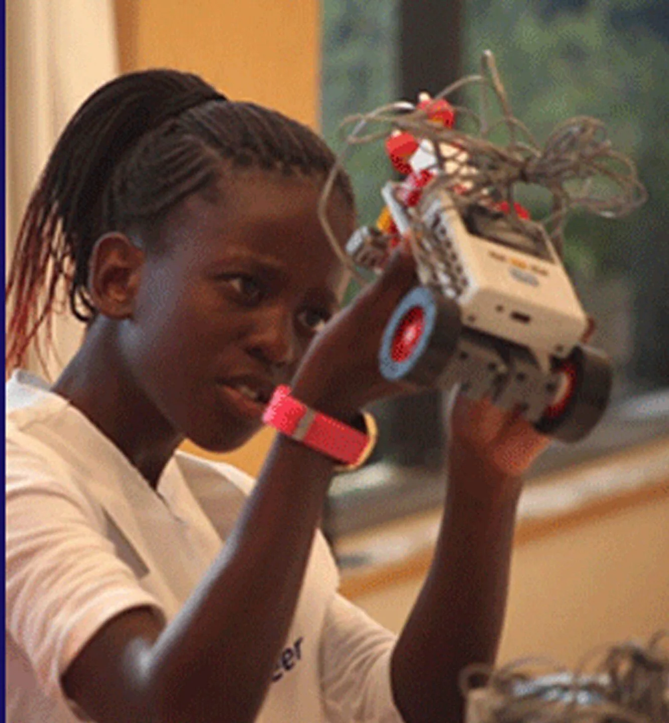 A student holding up a robot she has built and wired during a Little Engineer workshop