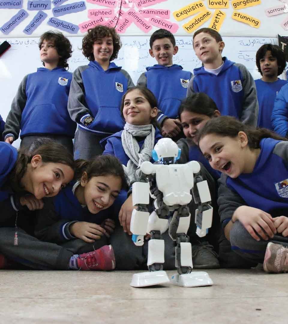 A class of students gathered around a humanoid robot