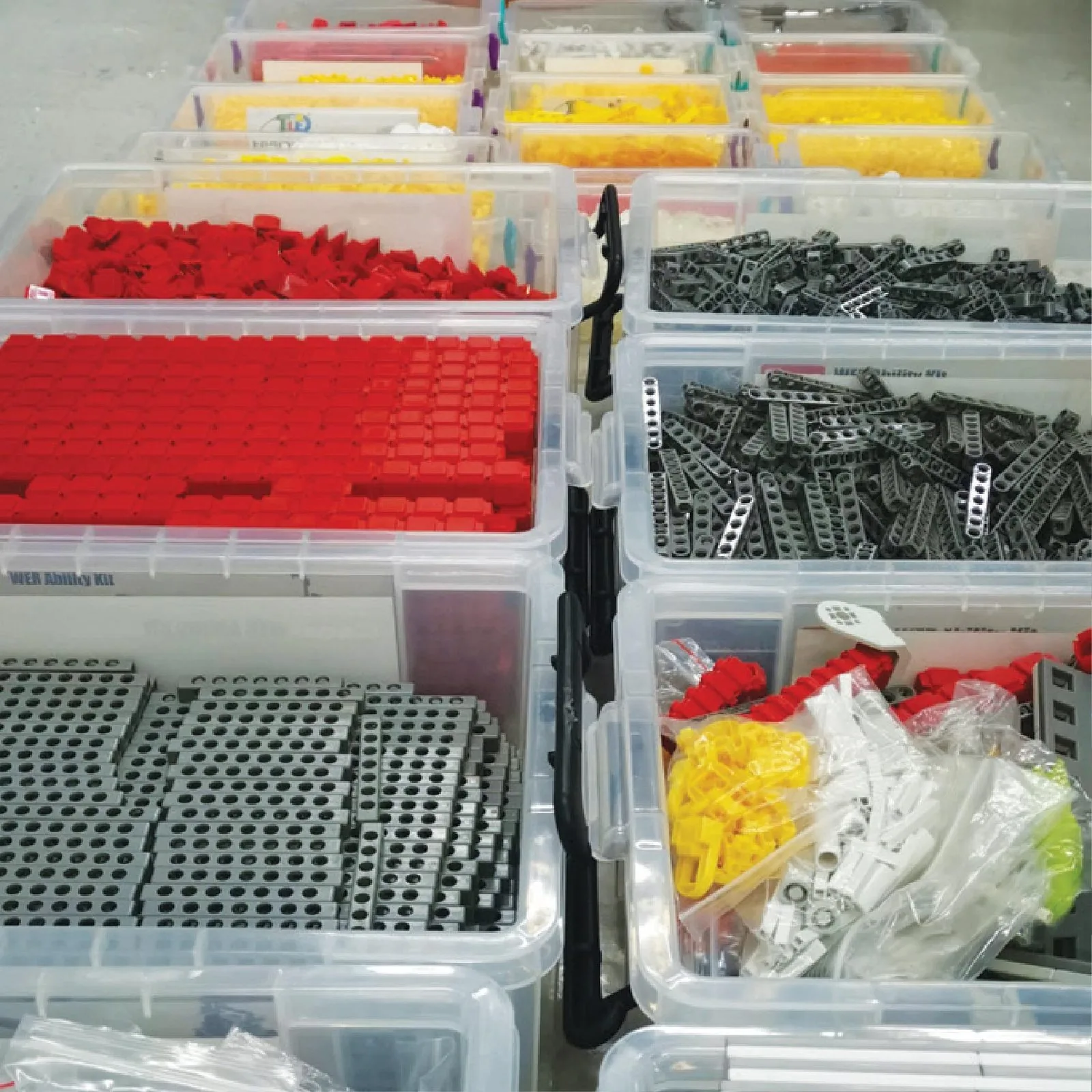 Sorted trays of robotics components, motors and structural parts from a Little Engineer kit