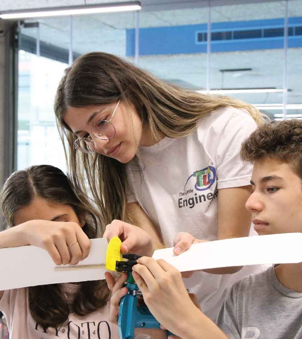 A Little Engineer instructor helping students build a renewable energy model